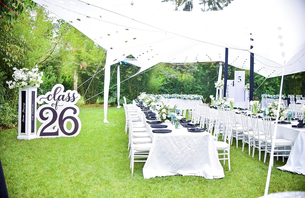 Graduation lunch under white sail tents with a Class of 26 sign