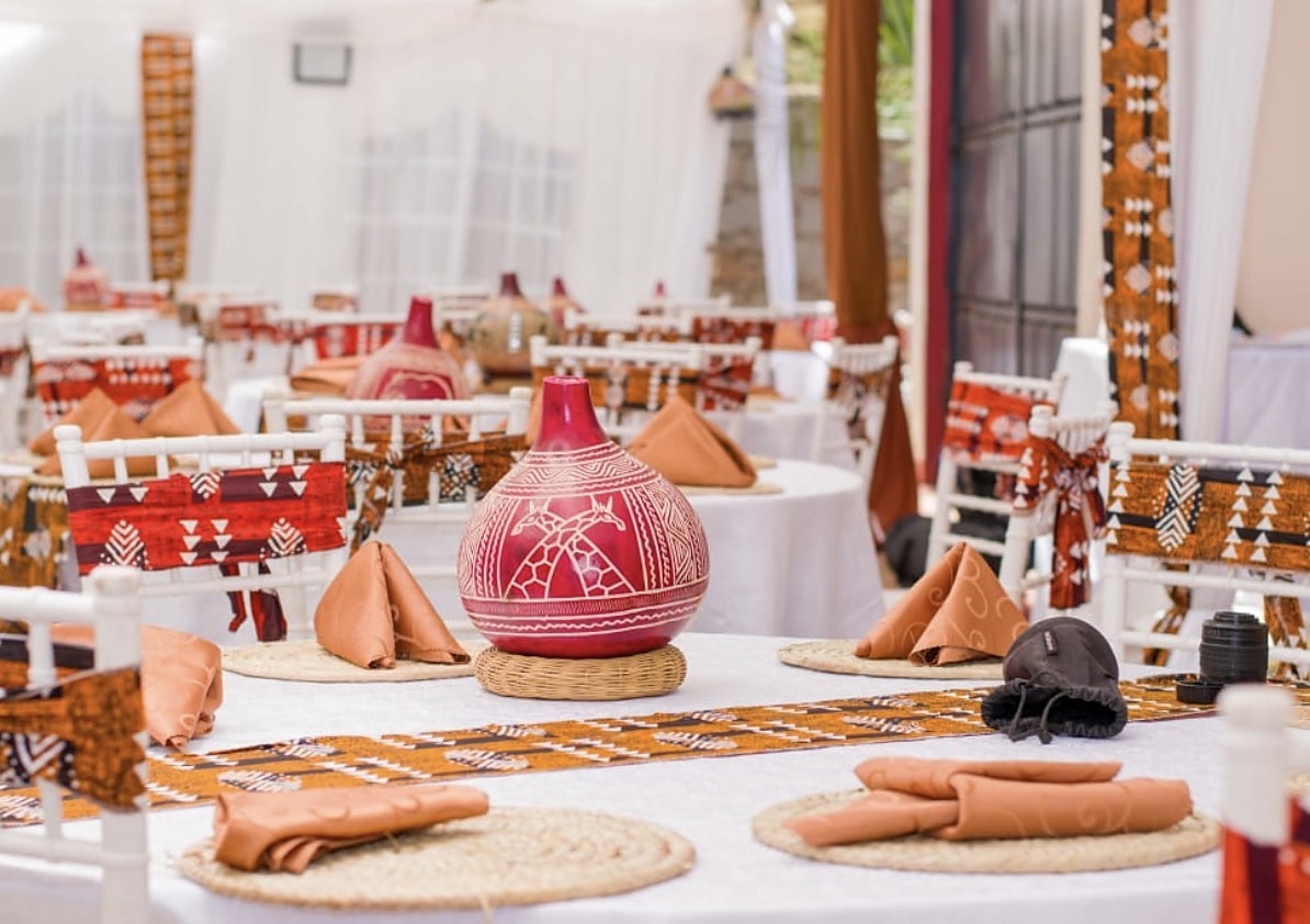 Painted gourd centrepiece on an African-print runner with folded terracotta napkins
