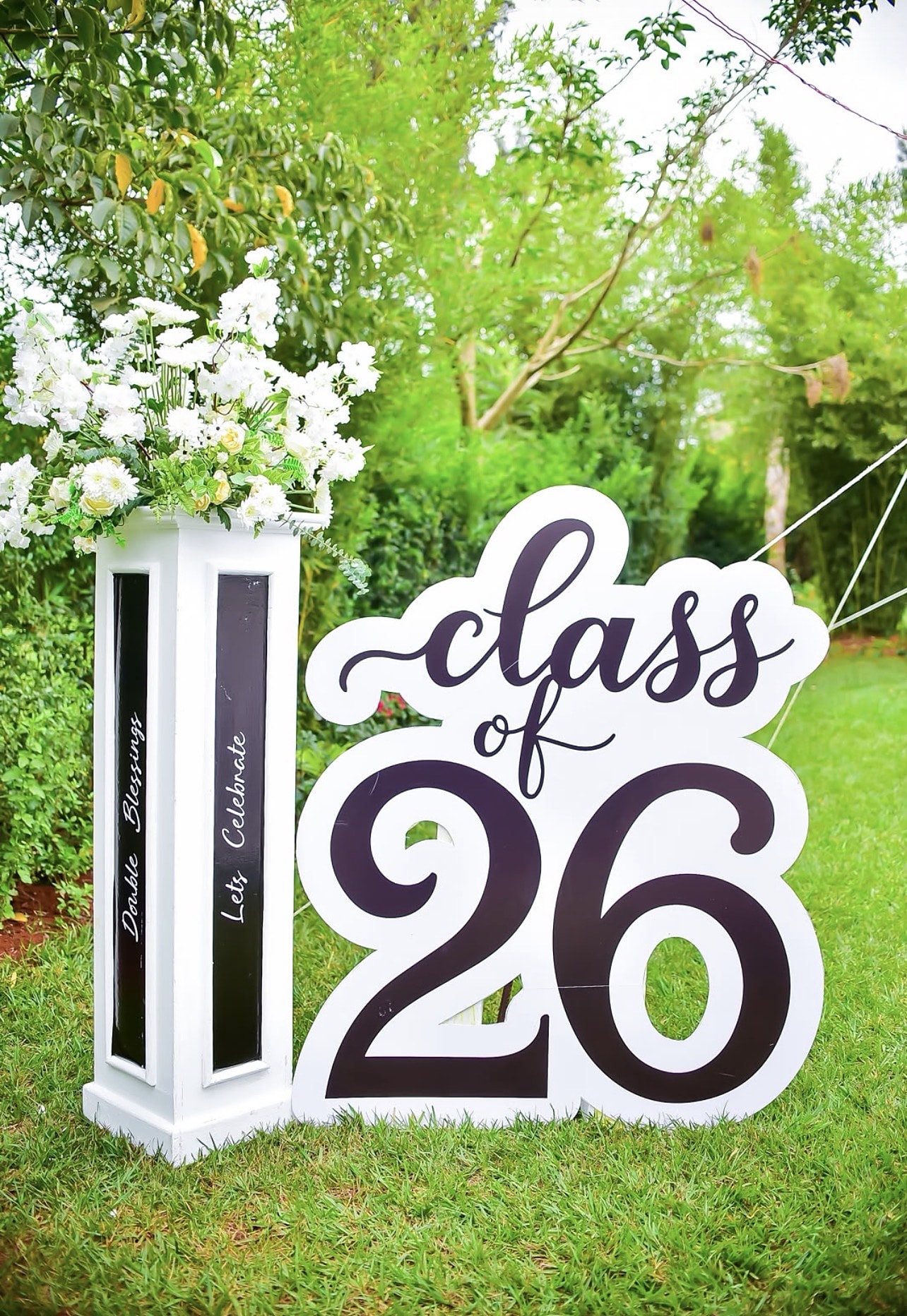 Class of 26 sign with white flowers on a lawn