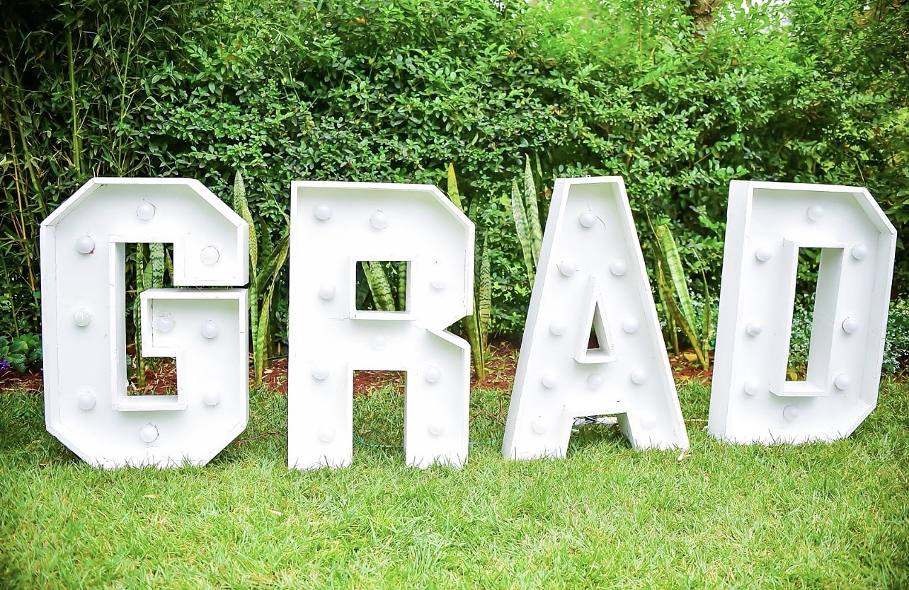 Light-up GRAD marquee letters on a garden lawn