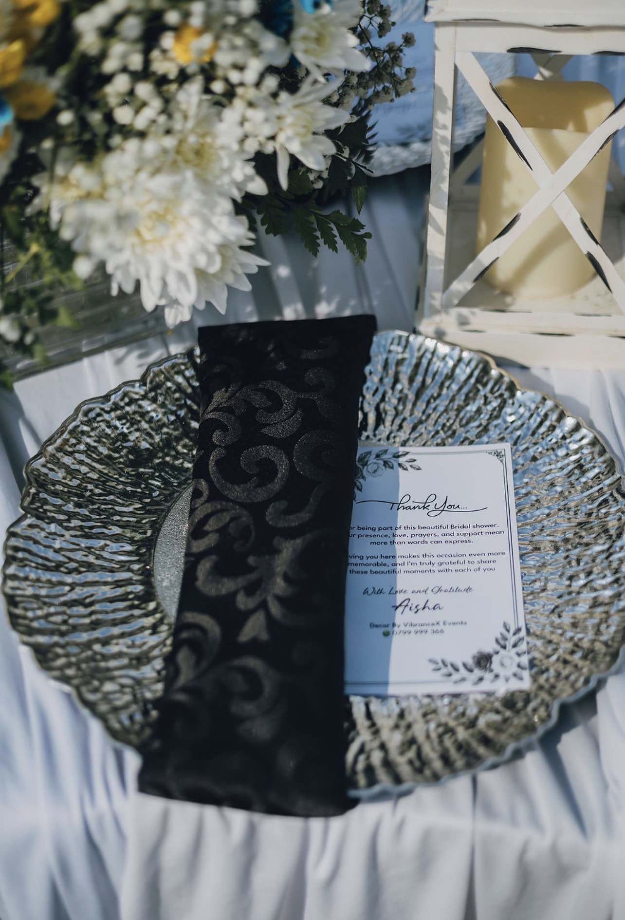 Place setting with a silver charger, black napkin and menu card